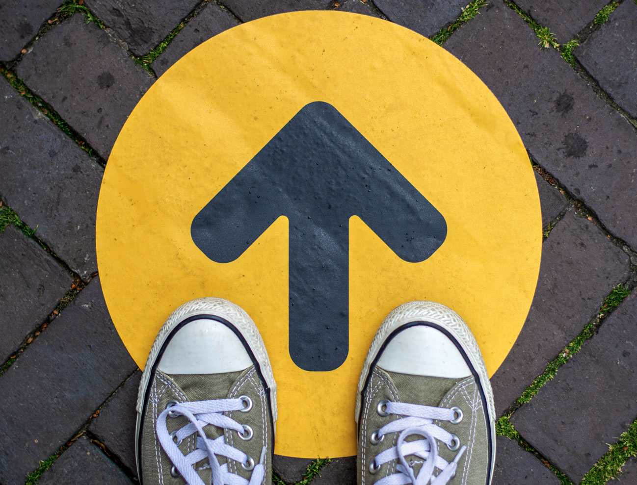 Photo of feet and an arrow painted on the ground to symbolize getting started